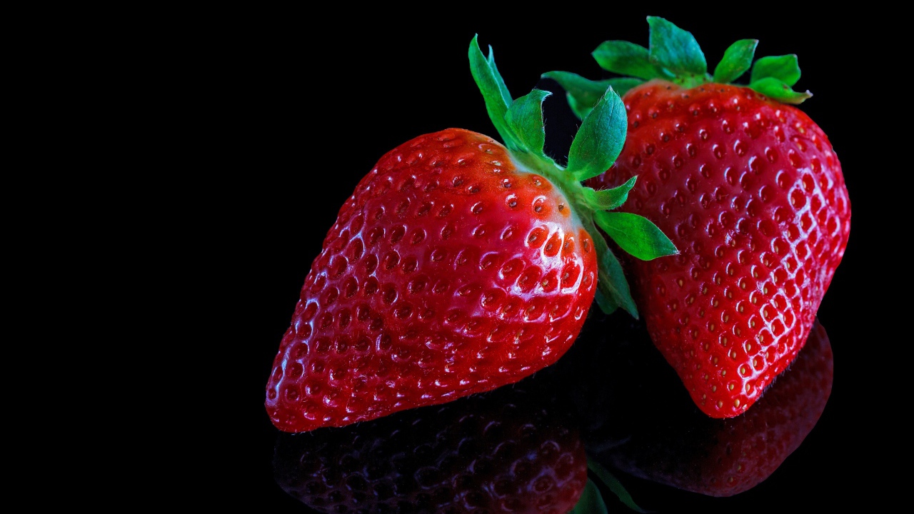 Красивая крупная красная клубника на черном  фоне