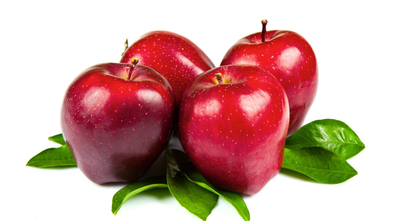 Красивые красные яблоки с зелеными листьями на белом фоне