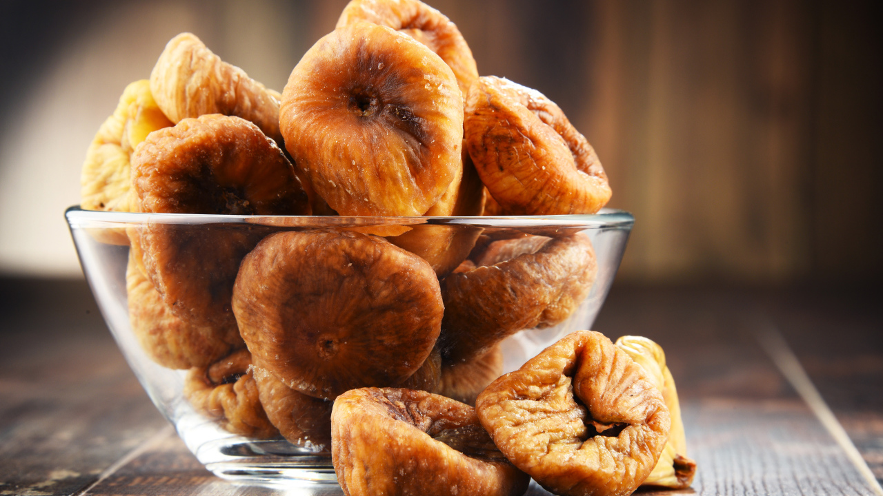 Инжир в стеклянной вазе на столе 