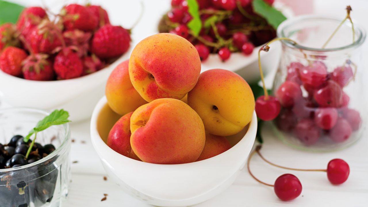 Свежие абрикосы на столе с ягодами крупным планом