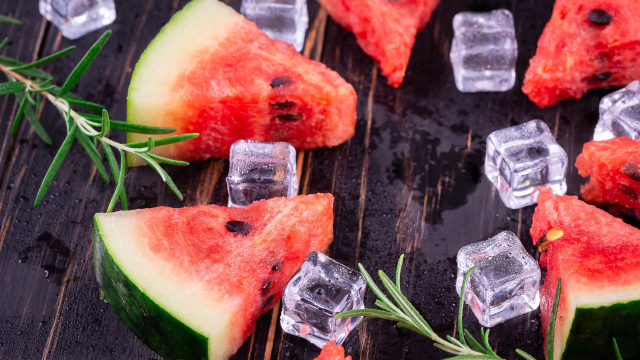 Кусочки арбуза на столе со льдом и розмарином