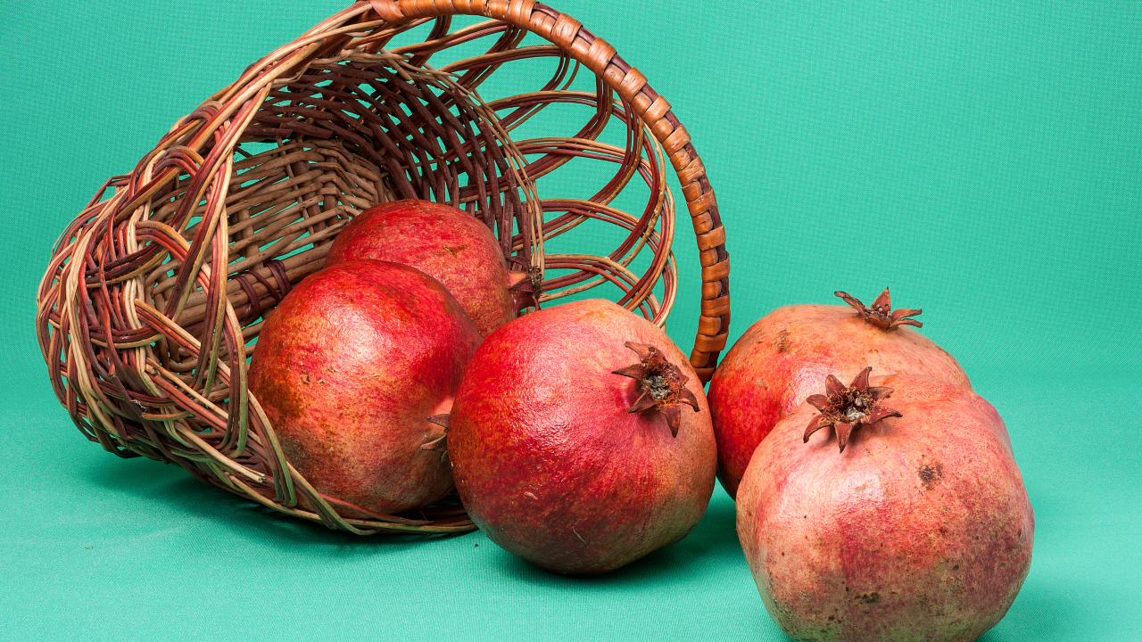 Плоды граната в корзине на голубом фоне