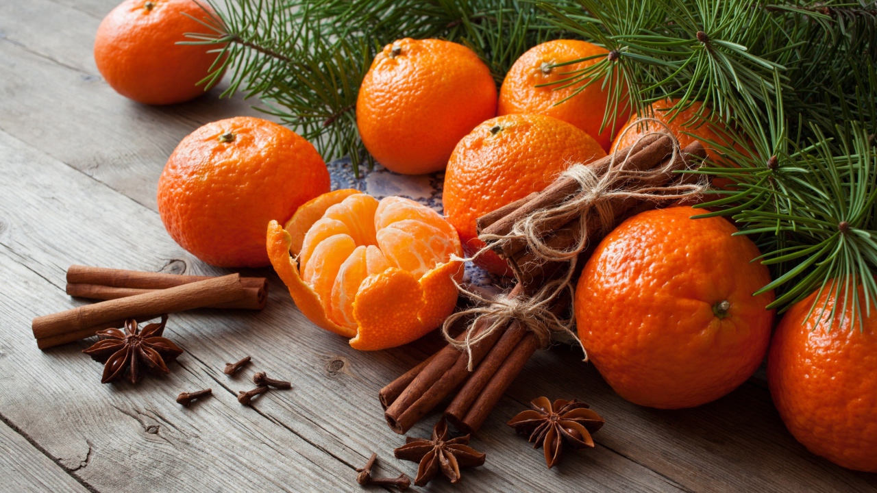 Вкусные спелые мандарины с корицей и бадьяном на столе с еловой веткой