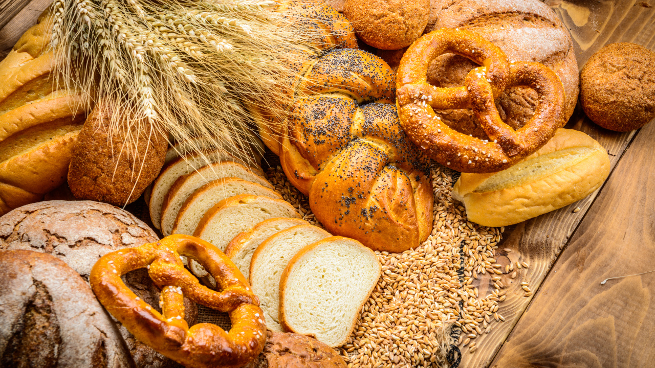 Свежая выпечка с колосьями и зернами пшеницы на столе 