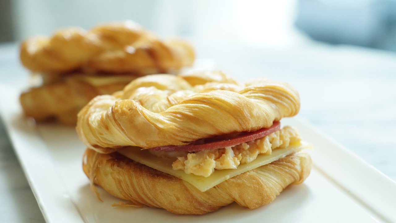 Две булочки с сыром и колбасой на столе