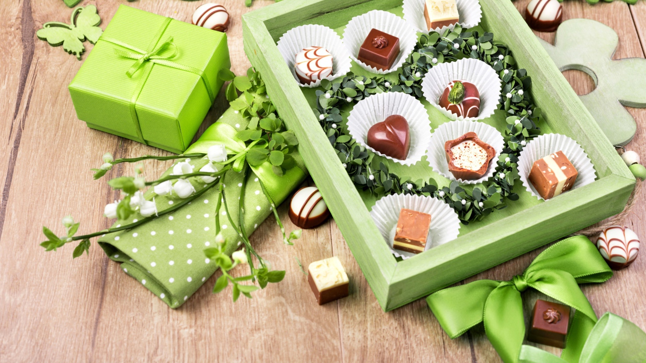 Коробка шоколадных конфет с подарком на столе