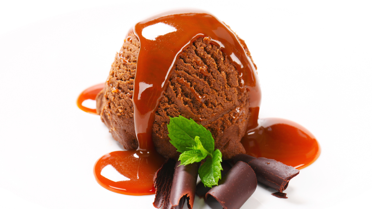 Шарик шоколадного мороженого с джемом на белом фоне 