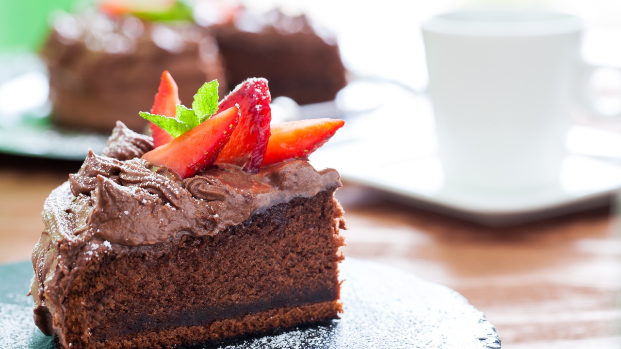 Кусок пирога с шоколадным кремом и кусочками спелой клубники 