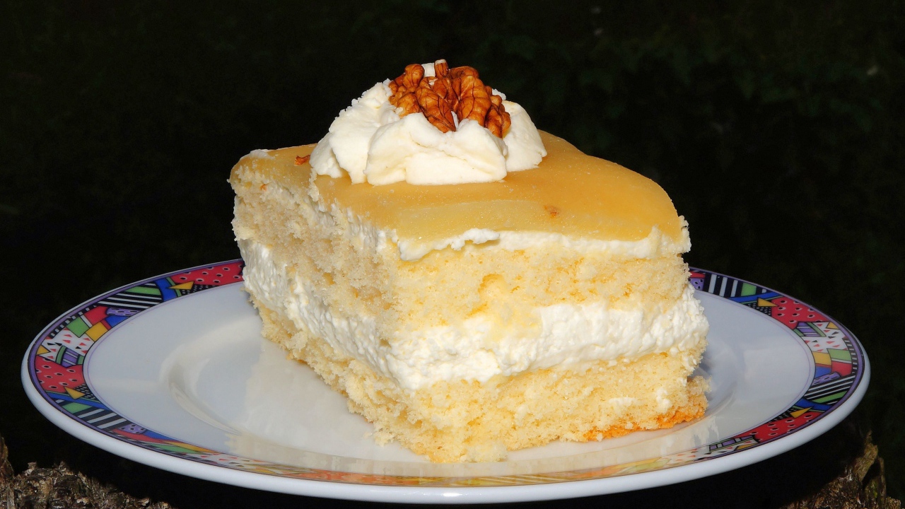 Кусок торта со сливочным кремом и грецкими орехами