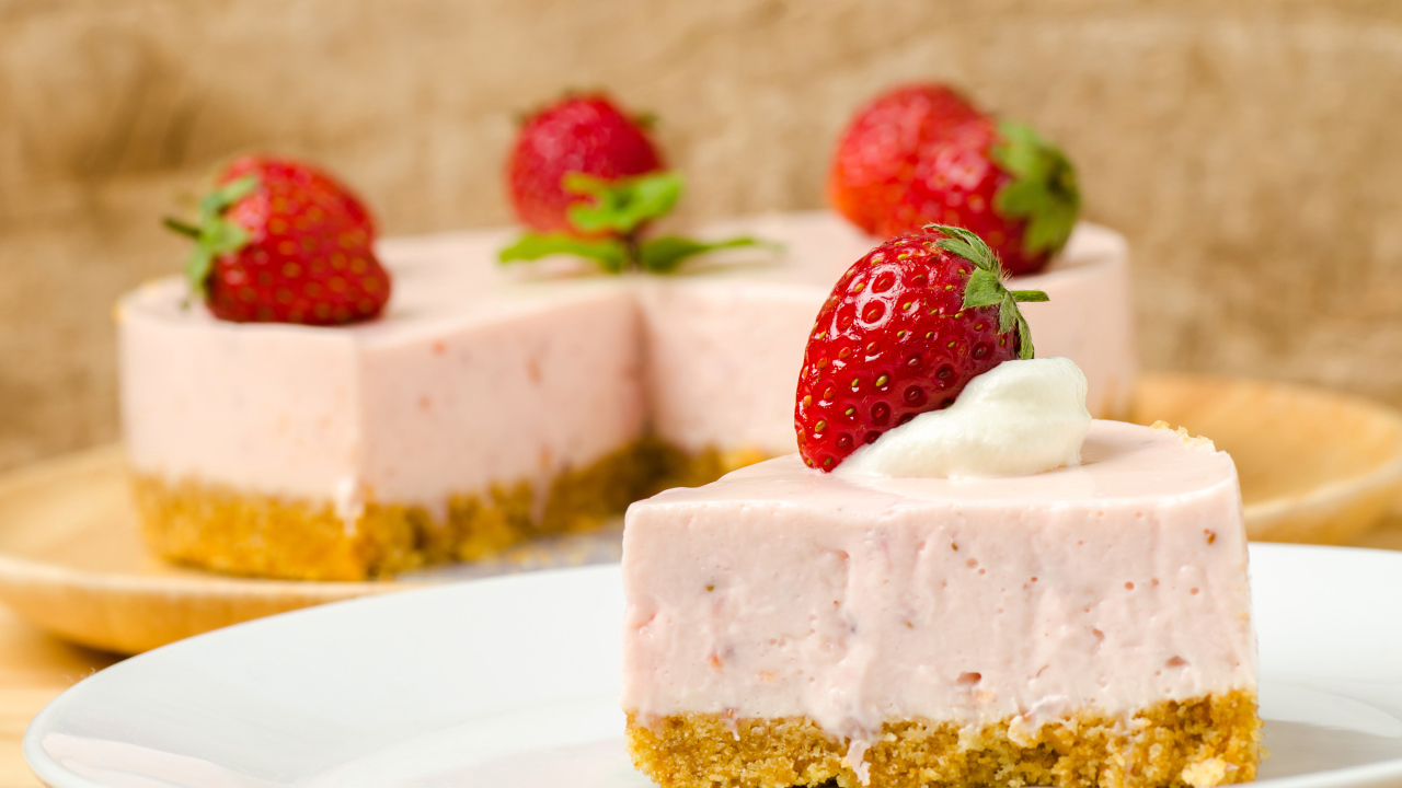 Кусок торта с клубникой на белой тарелке