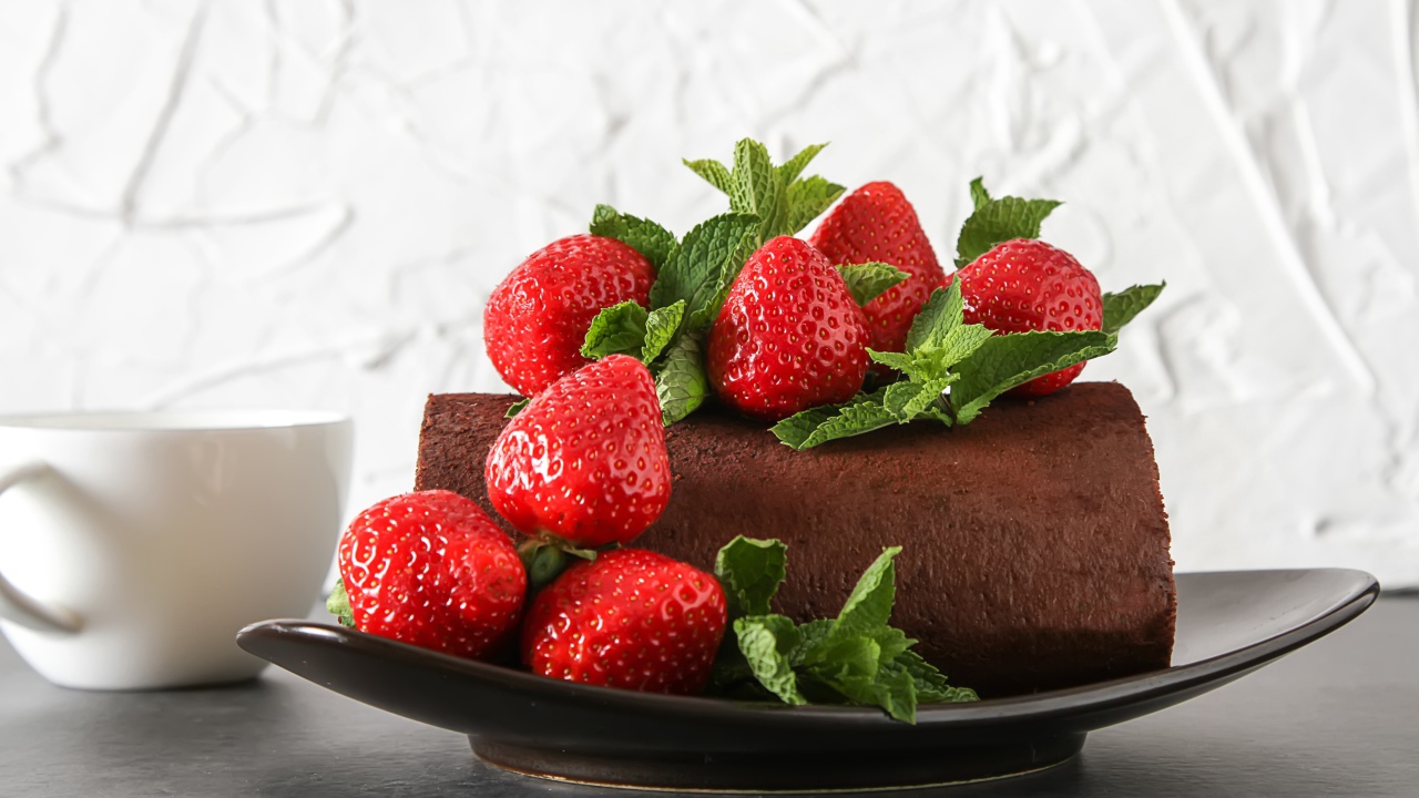 Кусок шоколадного торта со свежей клубникой на тарелке