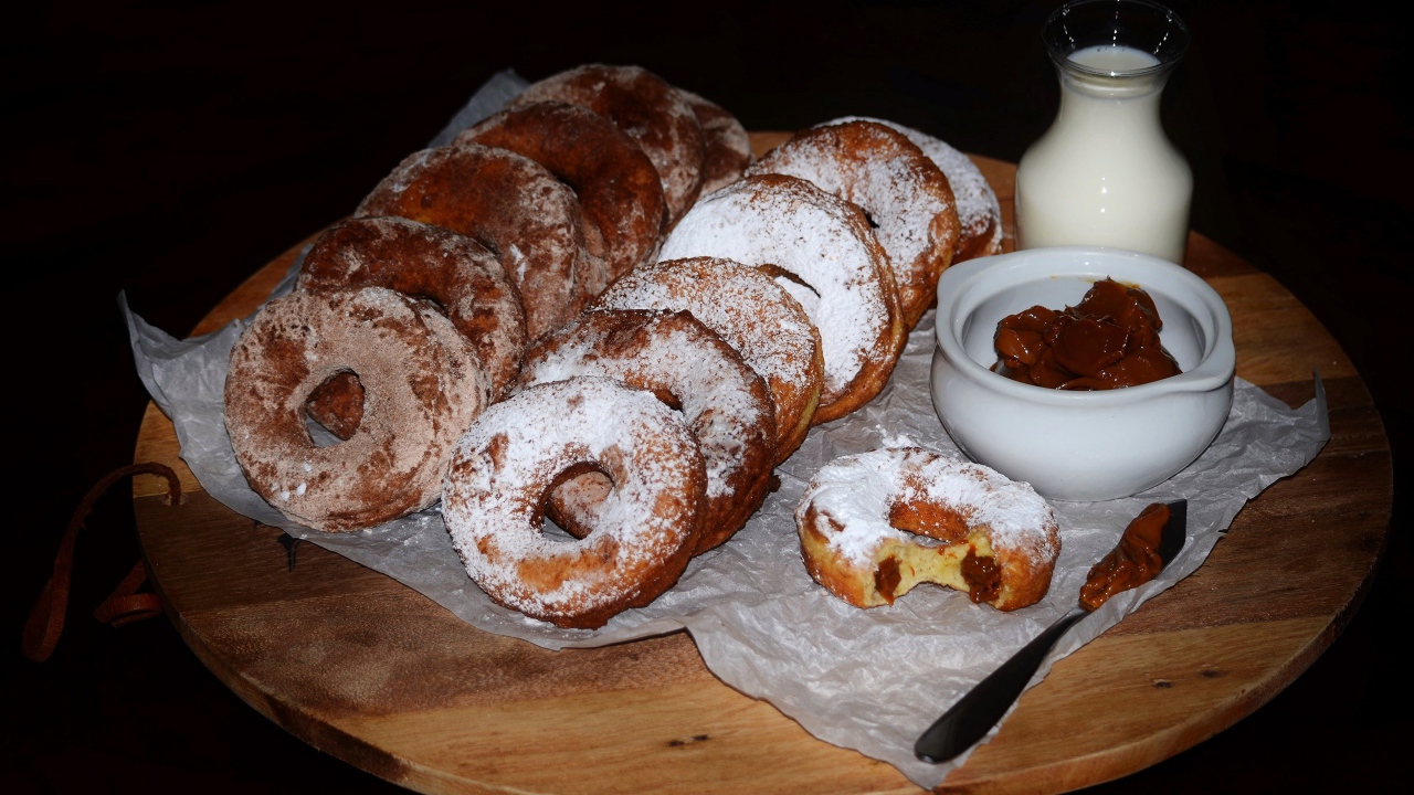 Аппетитные пончики со сгущенкой и свежим молоком на столе