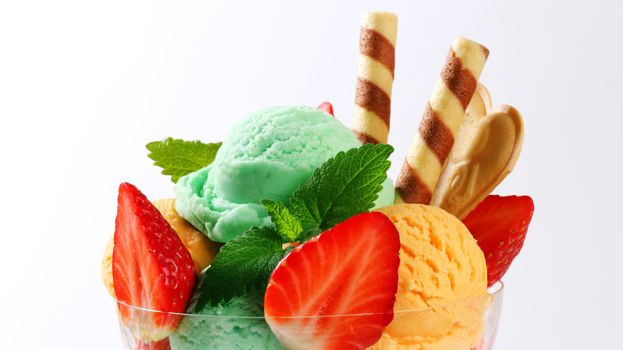 Шарики разноцветного мороженого с клубникой и трубочками
