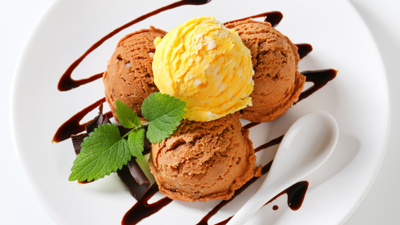 Шарики кофейного и фруктового мороженого на белой тарелке