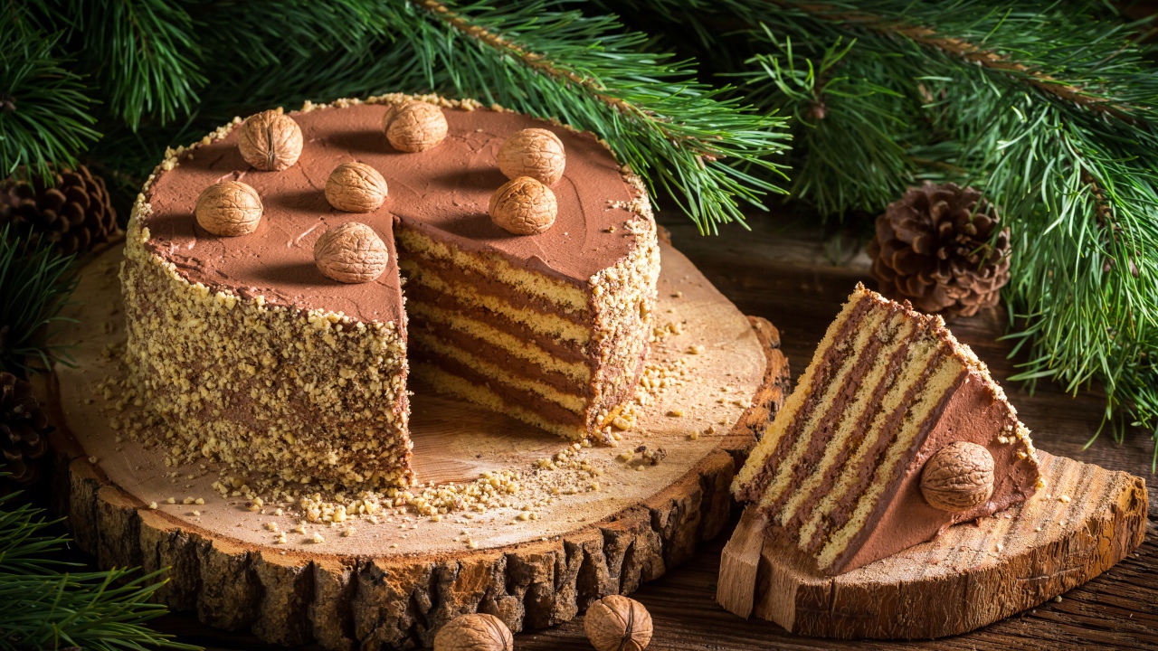 Торт с шоколадом и орехами на столе с еловой веткой