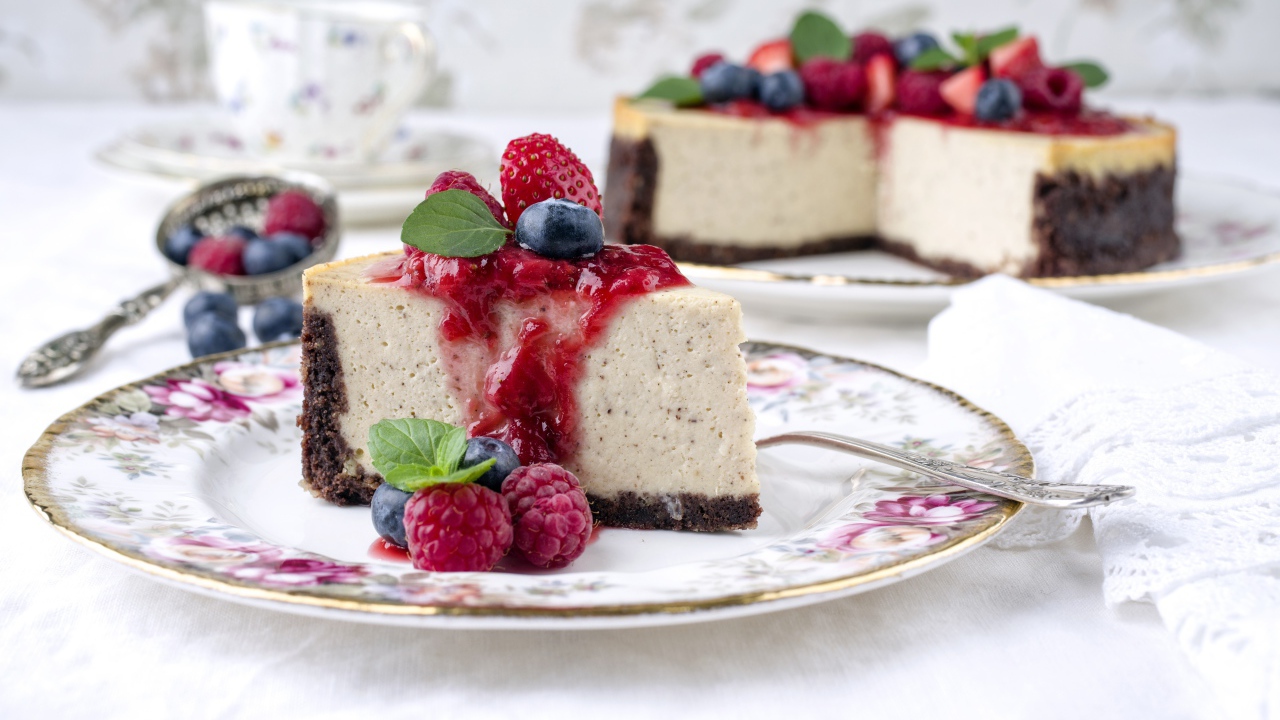 Чизкейк на столе с ягодами малины, черники и клубники