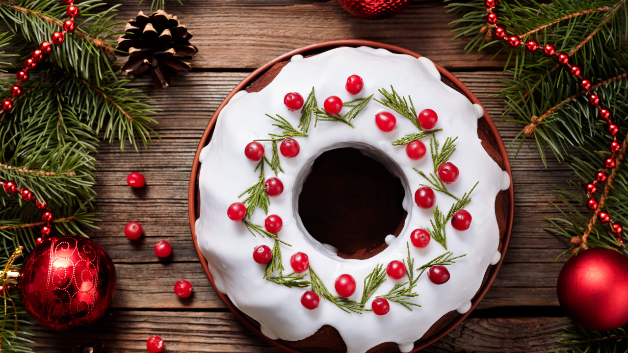 Рождественский пирог с ягодами клюквы на деревянном столе с еловыми ветками