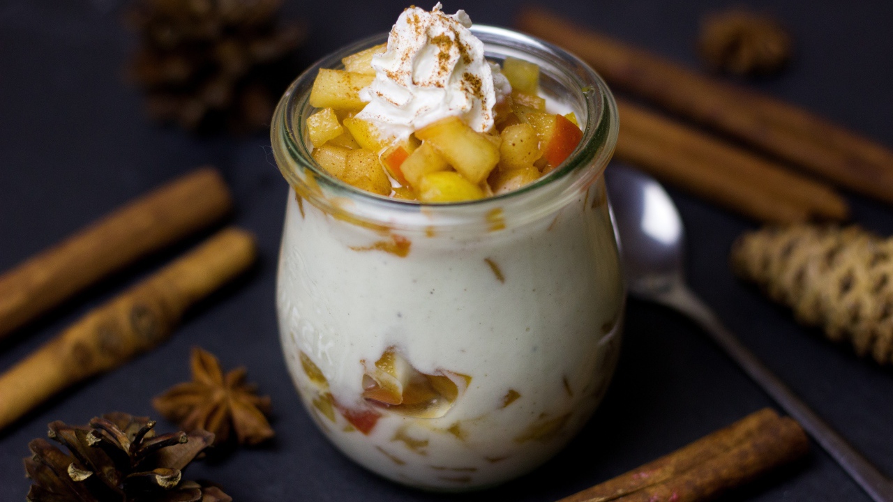 Десерт из йогурта с фруктами на столе с пряностями