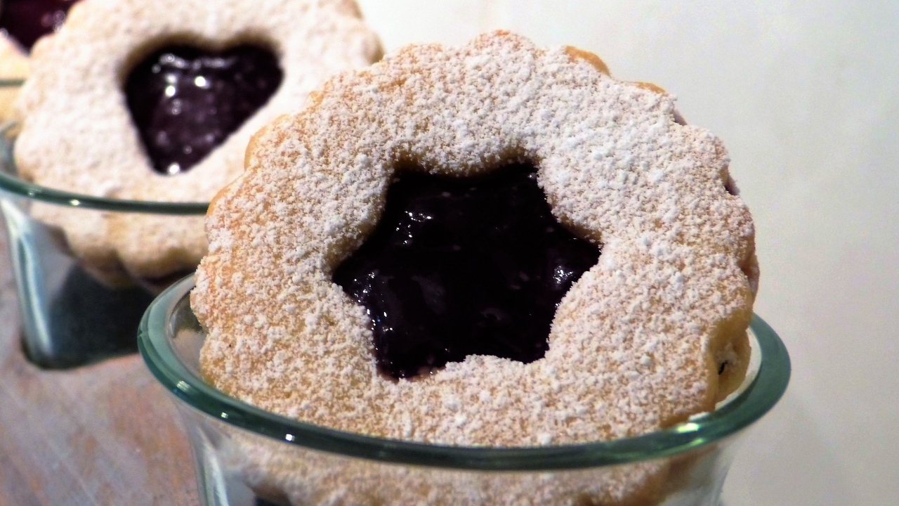 Фигурные печенья с джемом посыпанные сахарной пудрой 