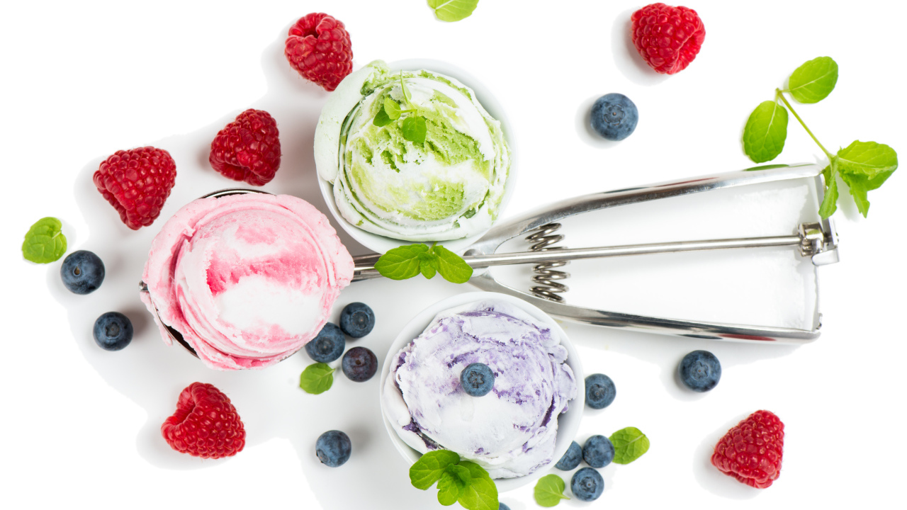 Шарики мороженого на столе с ягодами черники и малины 