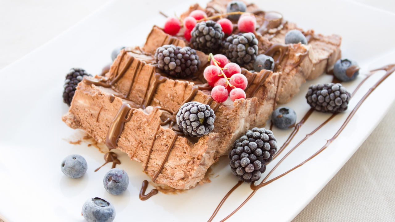 Мороженое с ягодами ежевики и красной смородины на белой тарелке 