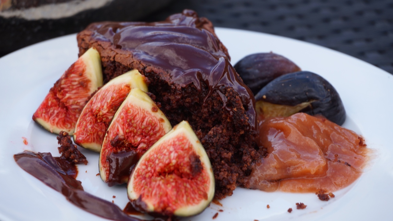 Кусок пирога с шоколадом на тарелке с кусочками инжира