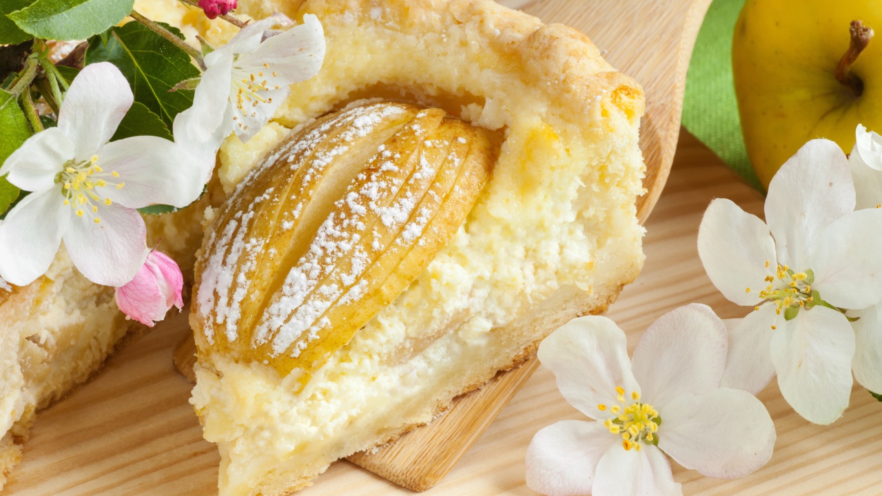 Кусок пирога с яблоками на деревянной лопатке с цветами яблони