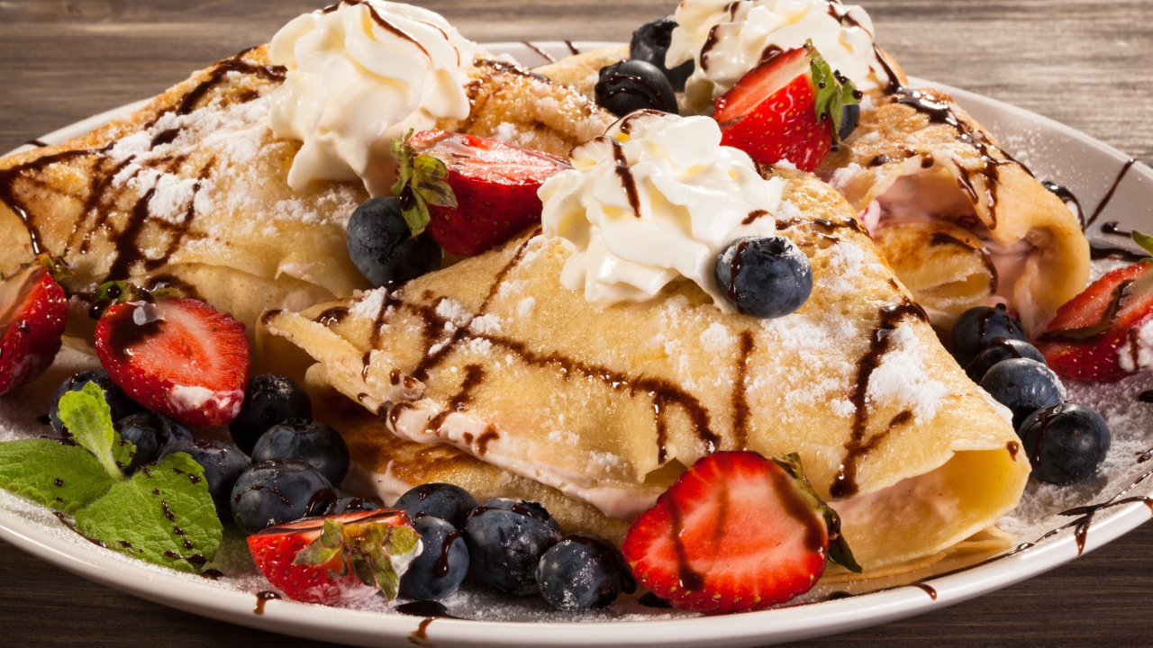 Сладкие блины с кремом, ягодами клубники и черники