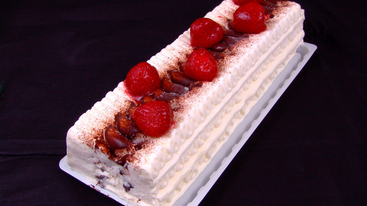 Белый торт с клубникой на черном фоне