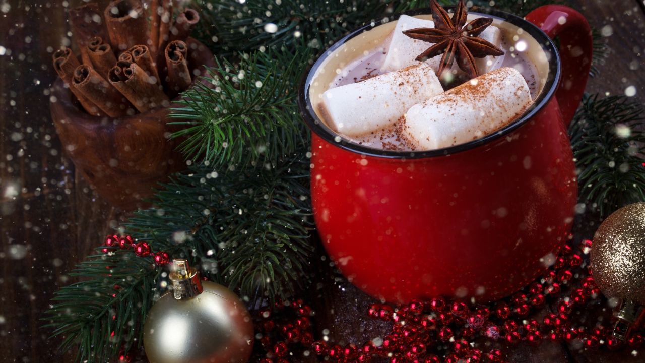 Чашка горячего какао с кусочками маршмеллоу и бадьяном на столе с еловой веткой 