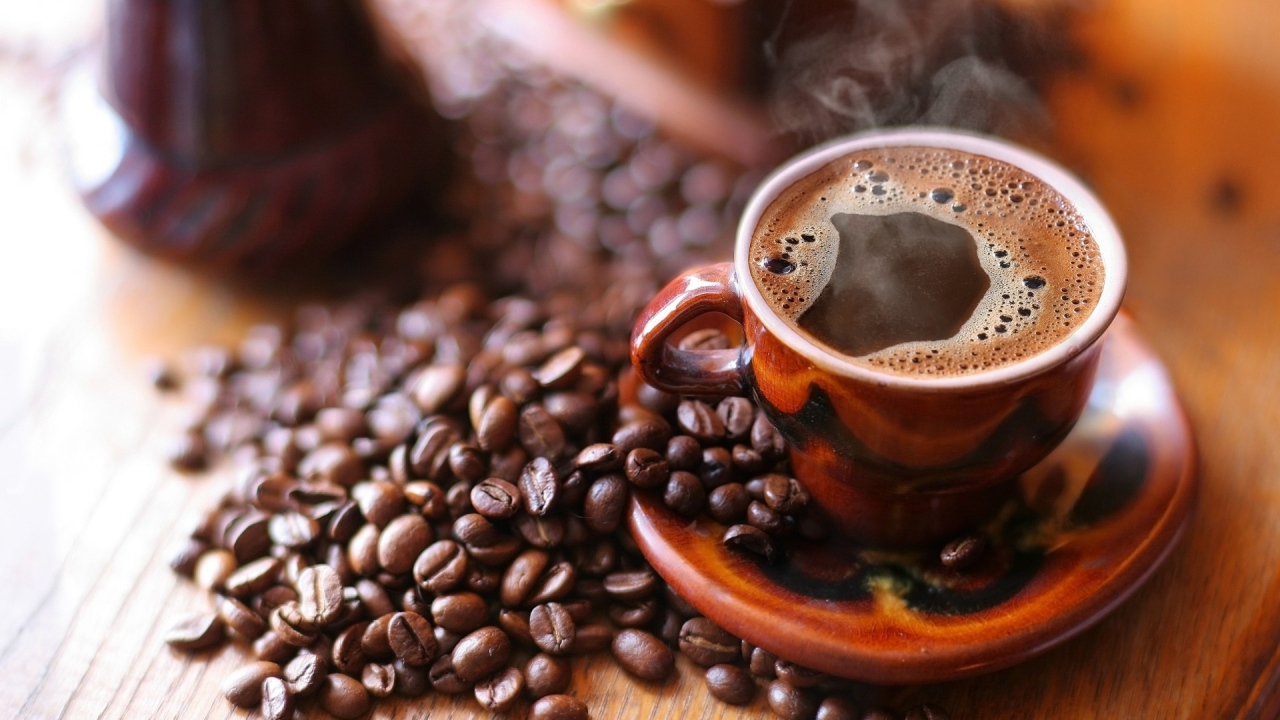 Чашка горячего кофе на столе с кофе 