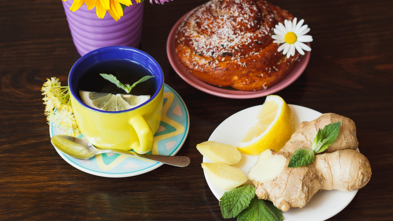 Липовый чай с имбирем и лимоном на столе со свежей булочкой