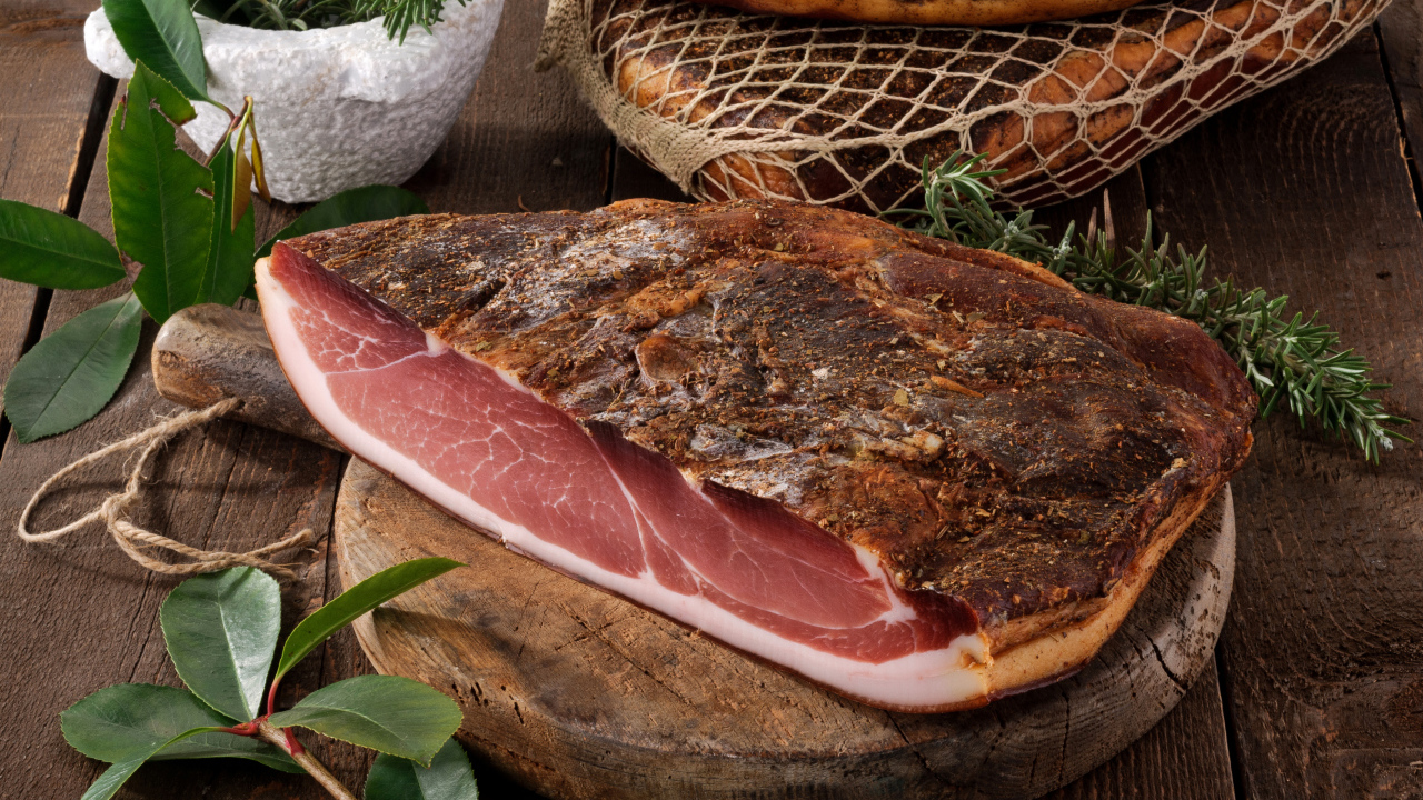 Кусок копченого мяса со специями на разделочной доске