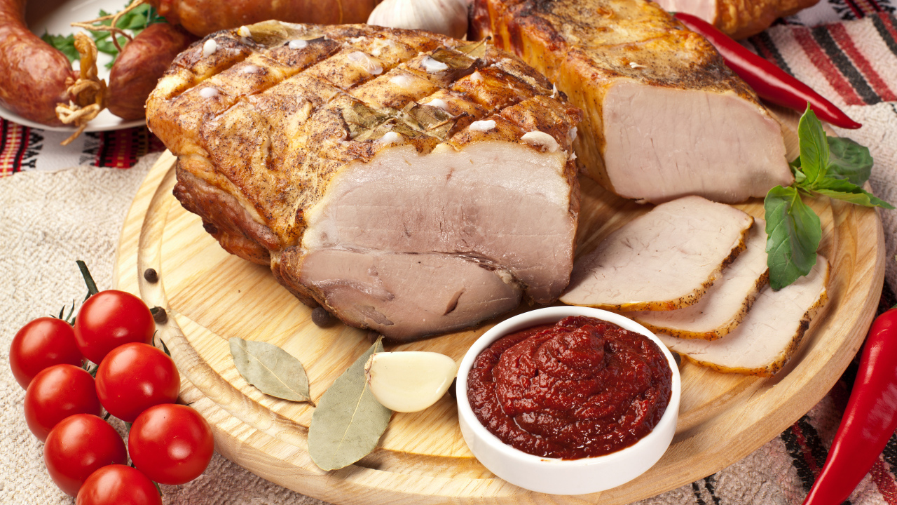 Аппетитная ветчина на столе с соусом и помидорами