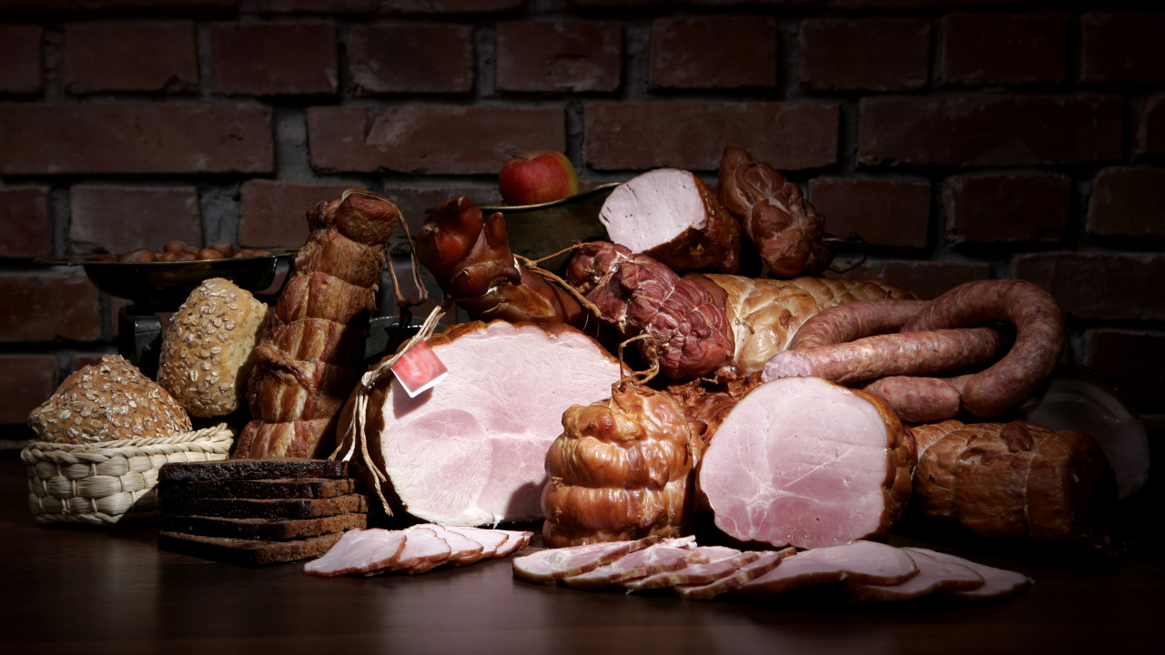 Аппетитные мясные продукты на фоне кирпичной стены 