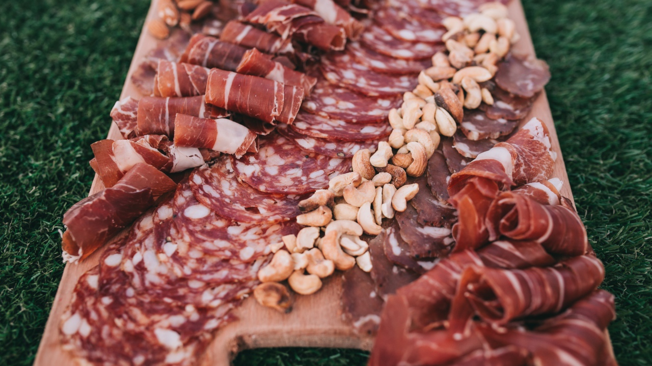 Мясная нарезка с орехами на разделочной доске