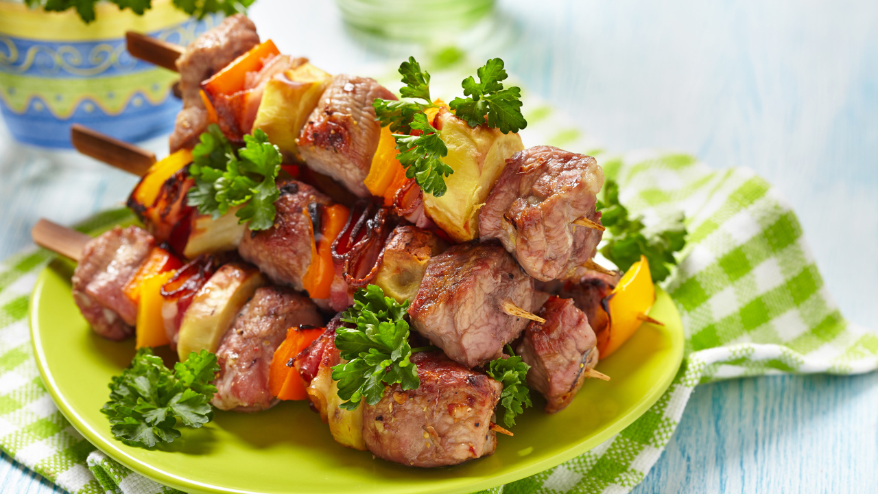 Шашлык с овощами на тарелке на столе