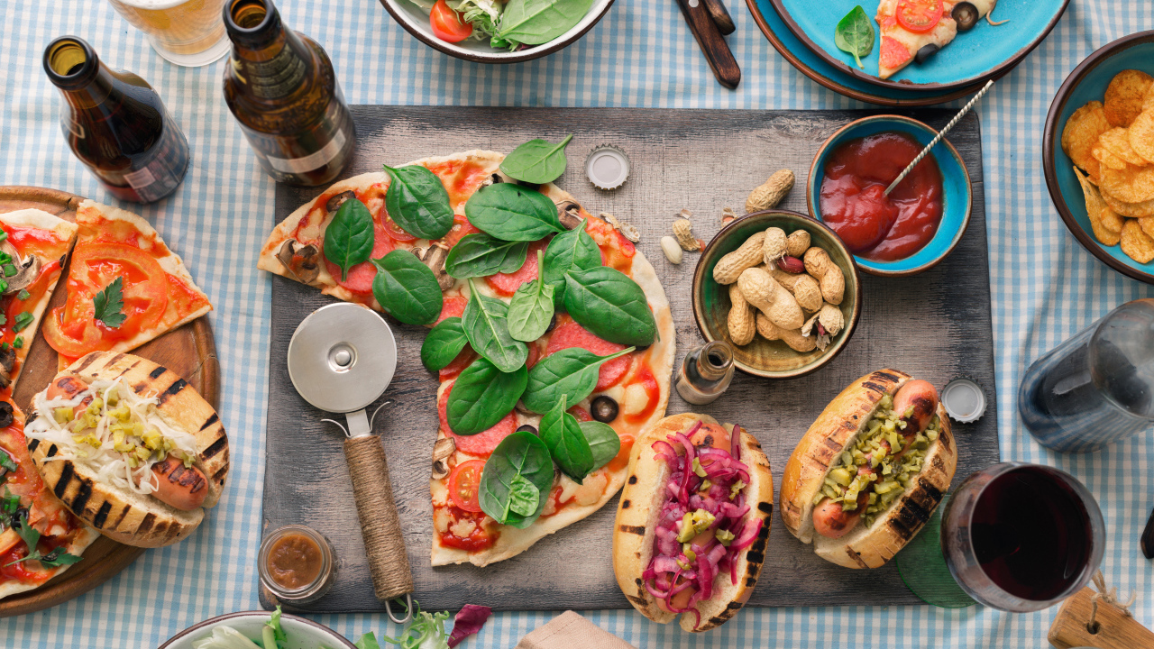 Пицца с хотдогами на столе с соусом