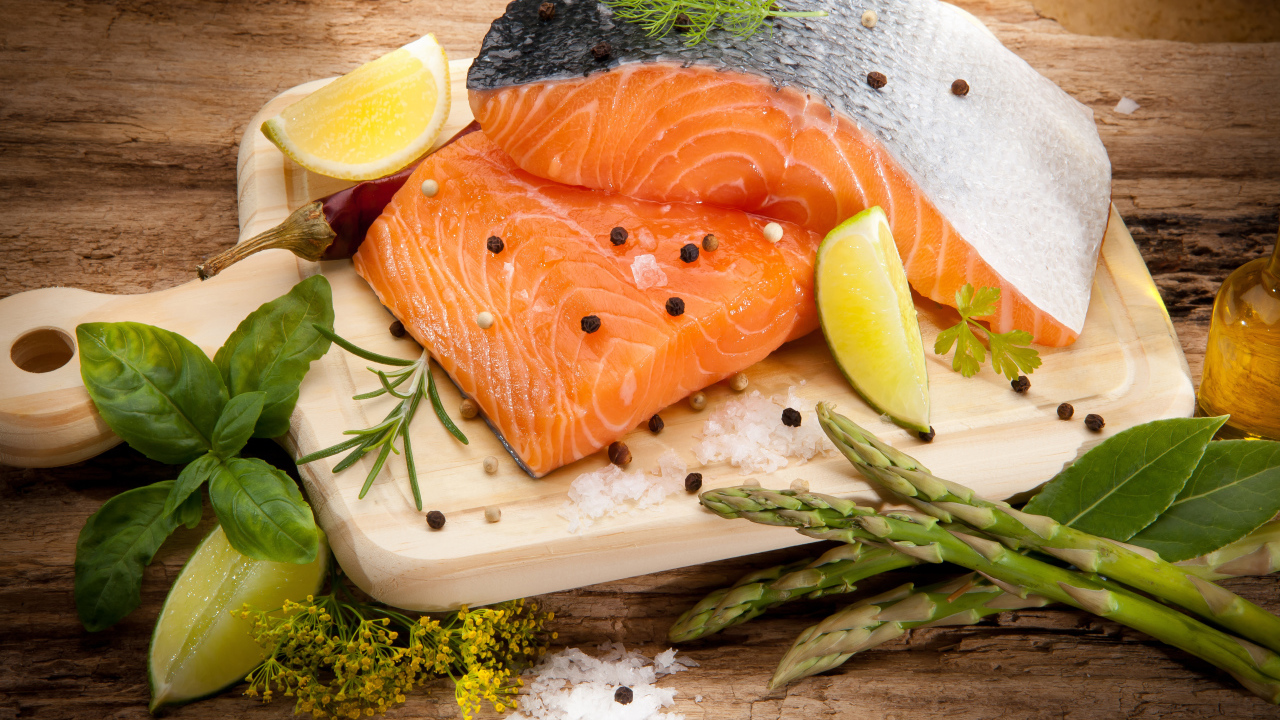 Филе красной рыбой на столе со спаржей и лаймом