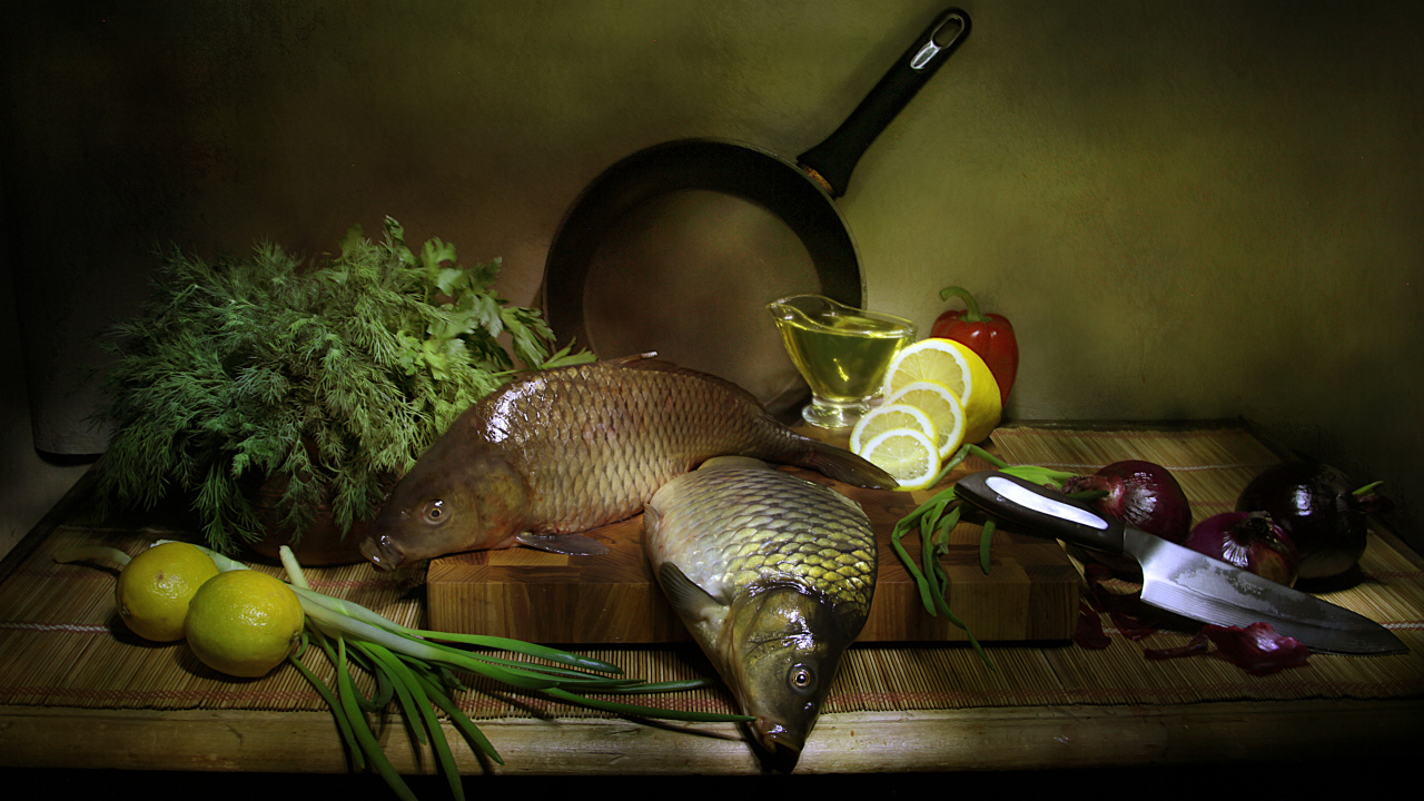 Сырая рыба на столе с зеленью, лимонами и луком 