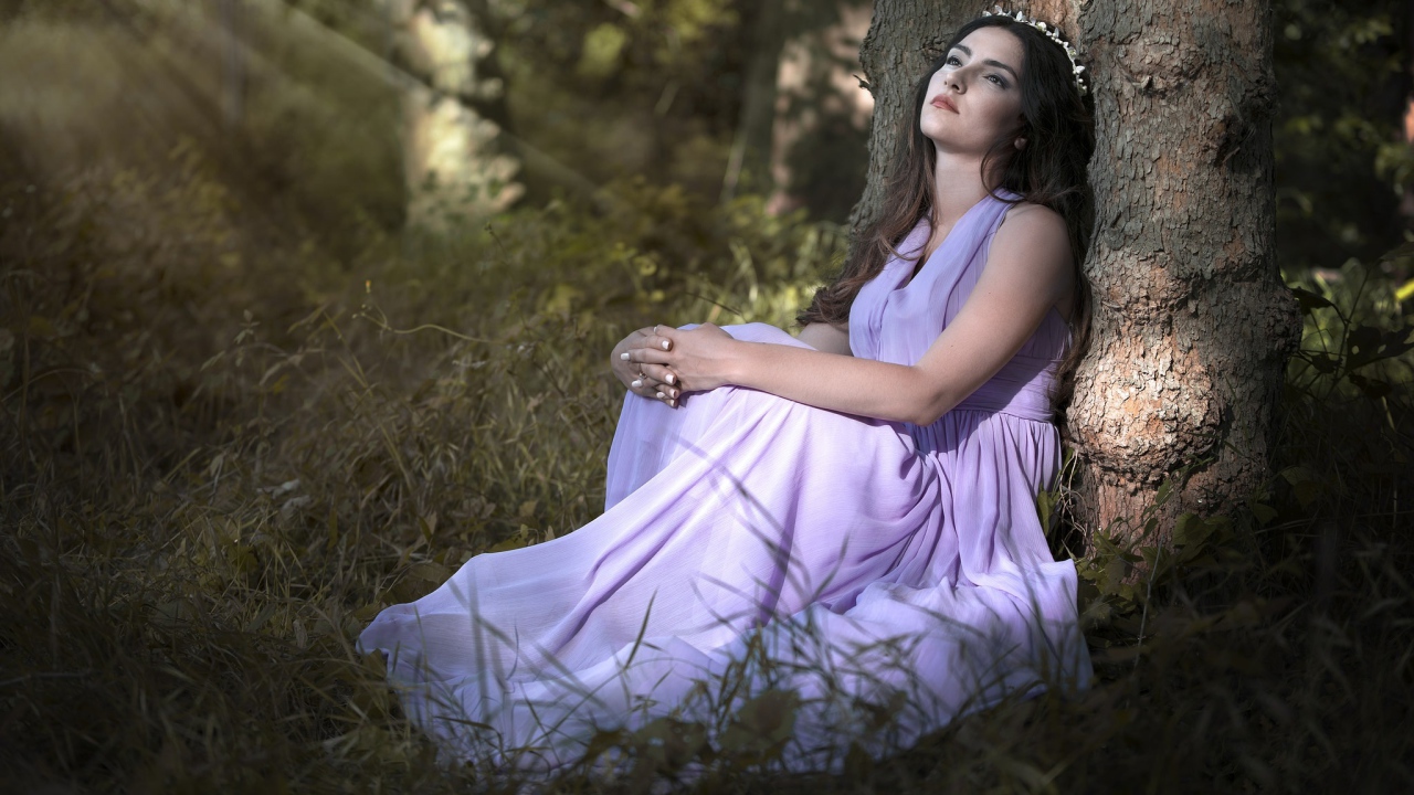 Девушка в красивом платье под деревом 