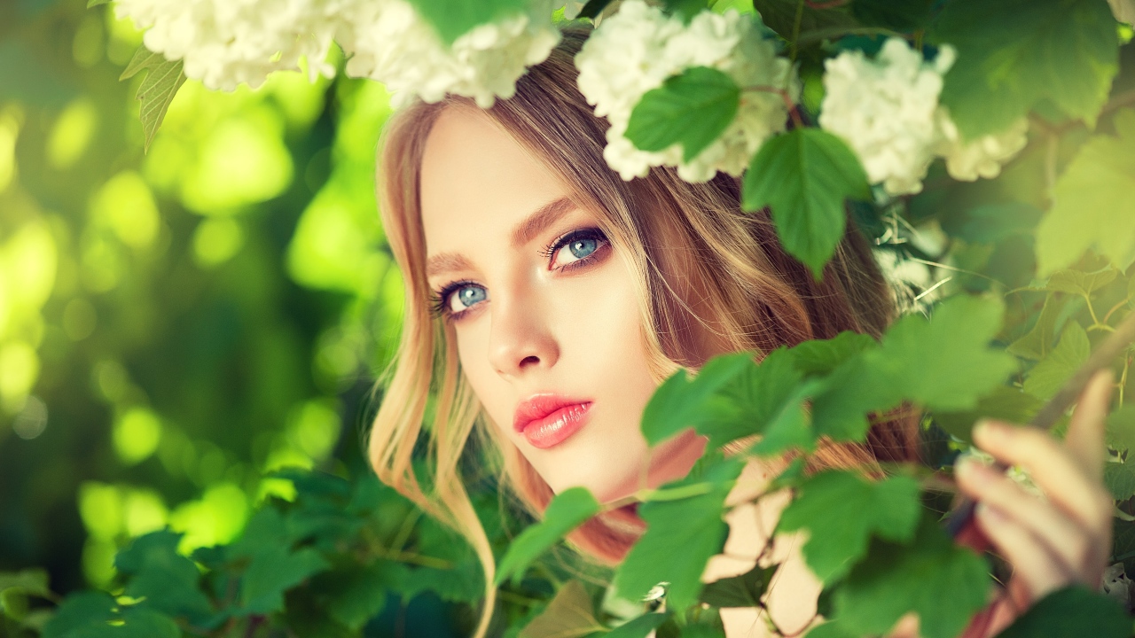 Красивая голубоглазая девушка в белых цветах 