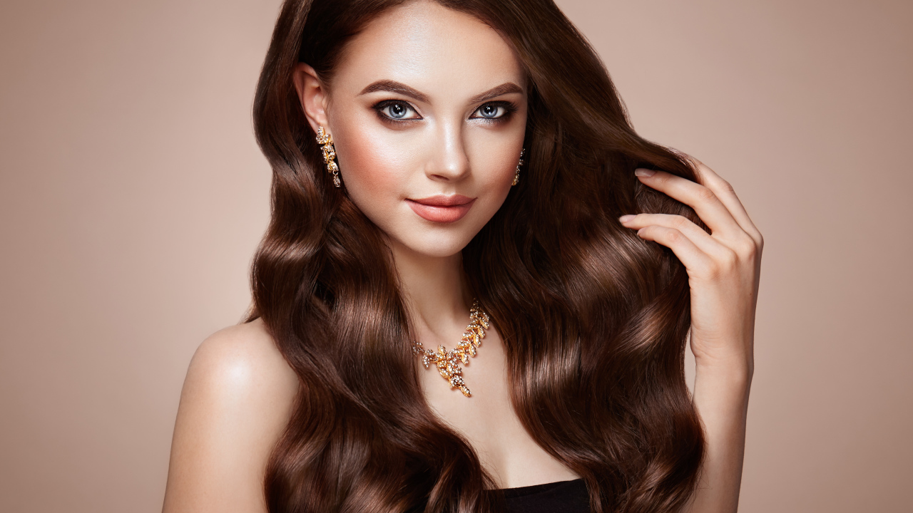 Красивая голубоглазая длинноволосая девушка шатенка с золотым украшением на шее 