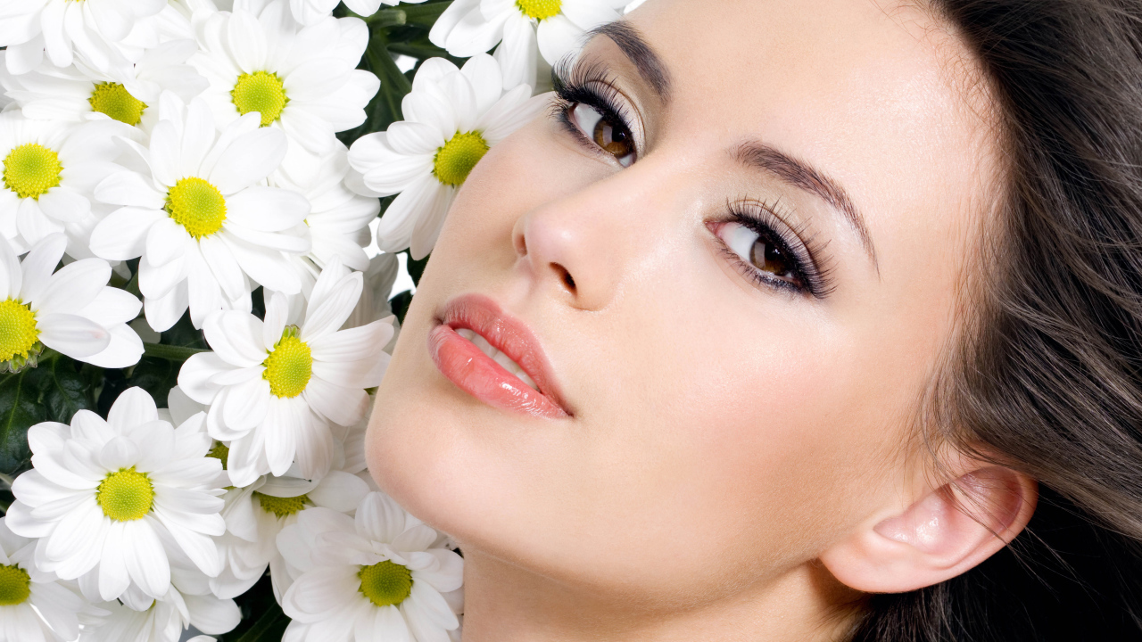 Красивая кареглазая девушка с белыми цветами хризантемы