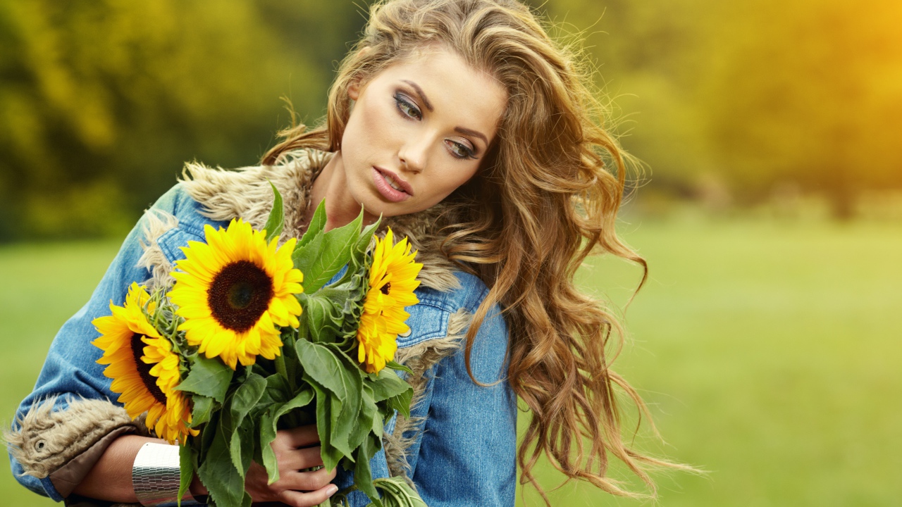 Красивая шатенка с букетом подсолнухов в руке
