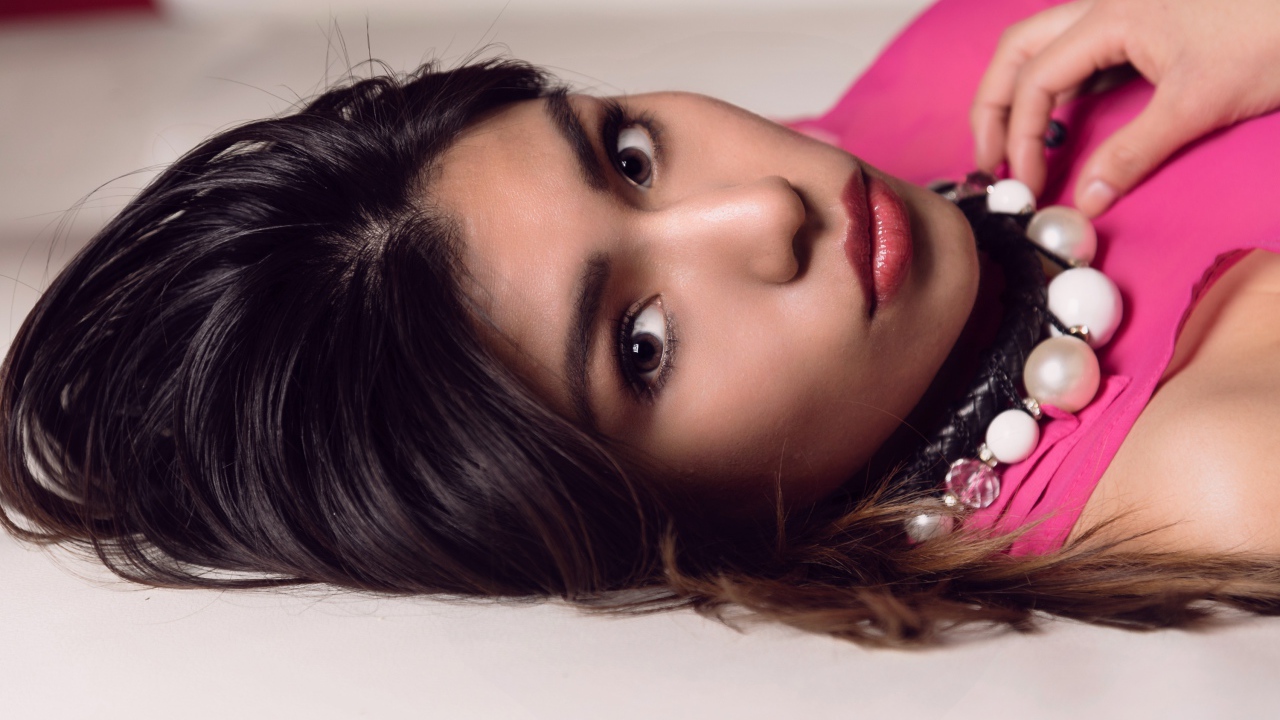 Красивая брюнетка с большими бусами на шее