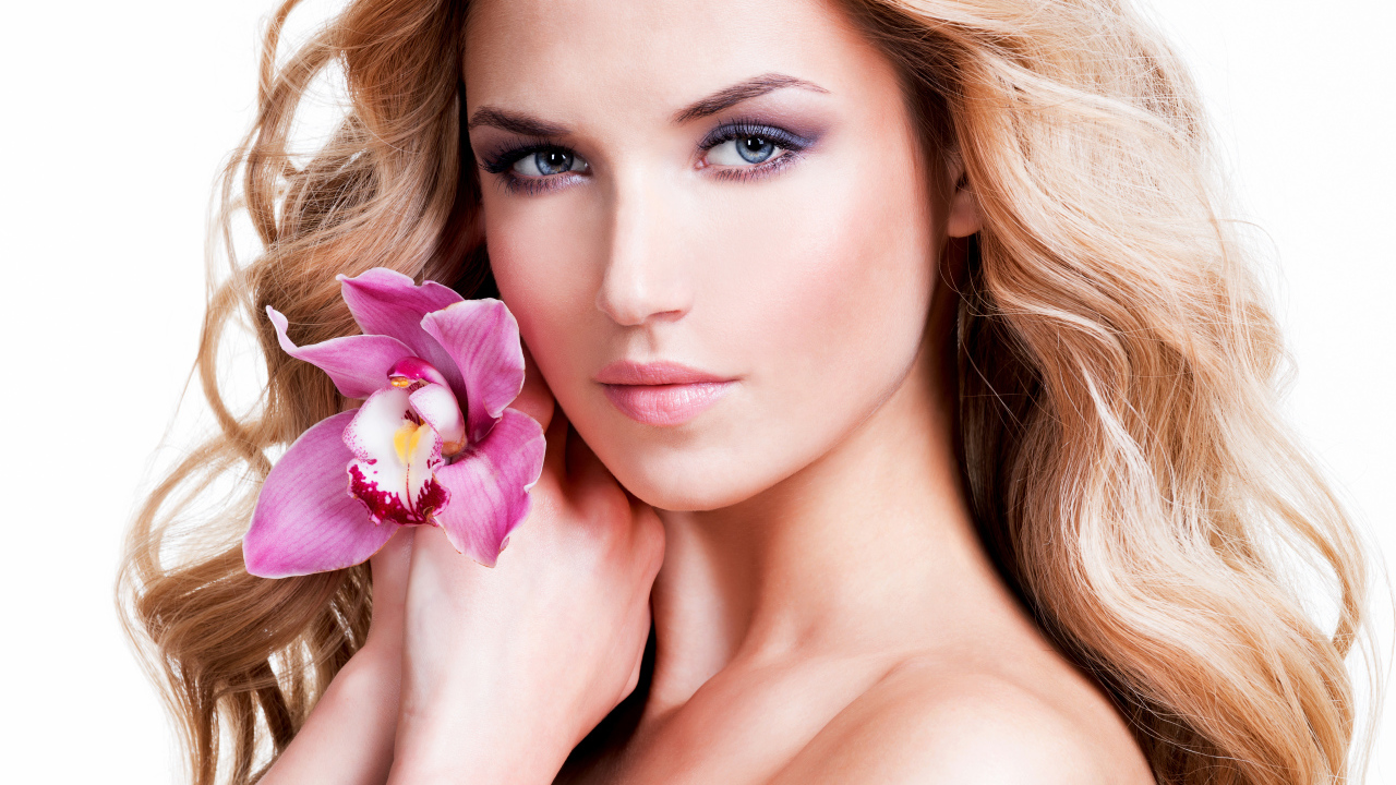 Красивая нежная блондинка с цветком орхидеи на белом фоне