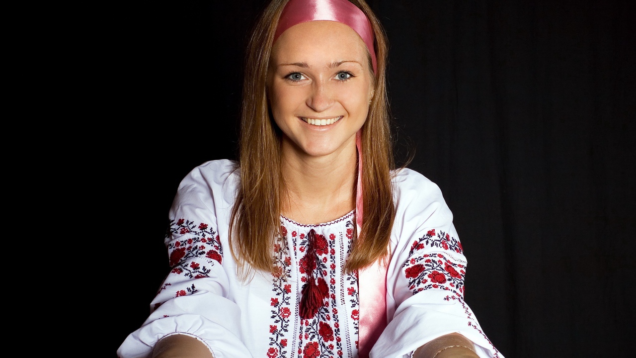 Красивая девушка в вышитой рубашке на черном фоне