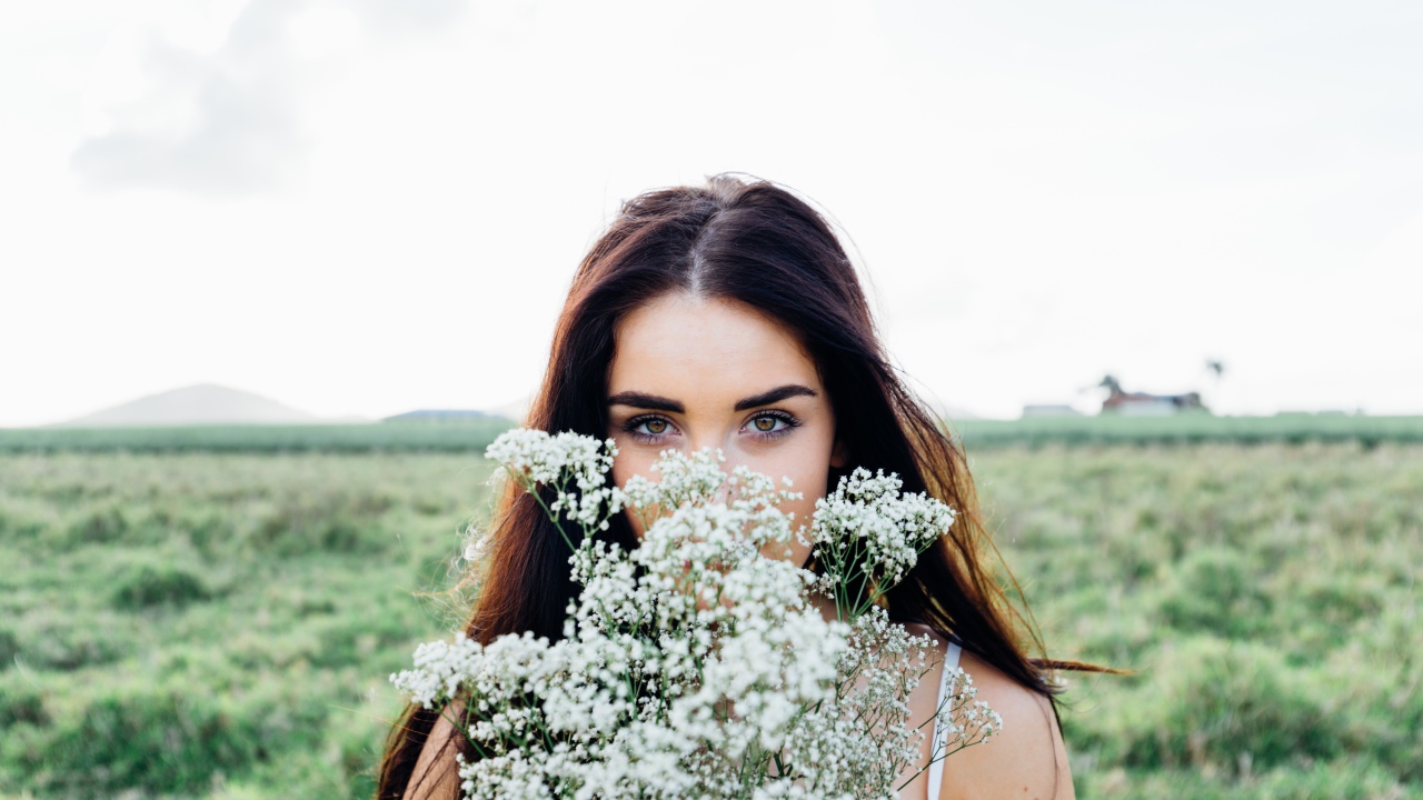 Красивая девушка с букетом полевых цветов