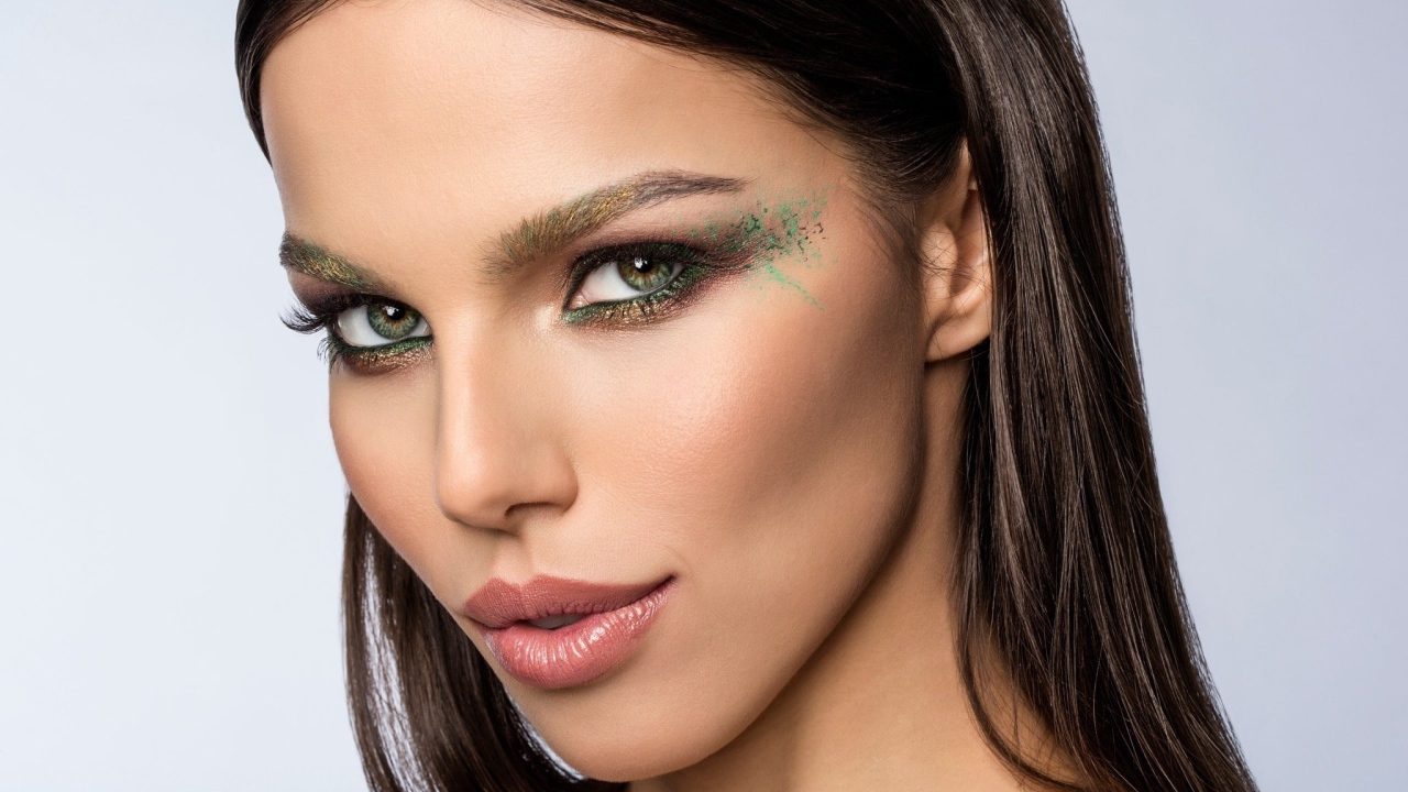 Красивая зеленоглазая девушка с макияжем на лице